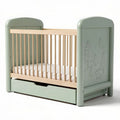 Convertible crib in soft green finish with natural wood accents and drawer